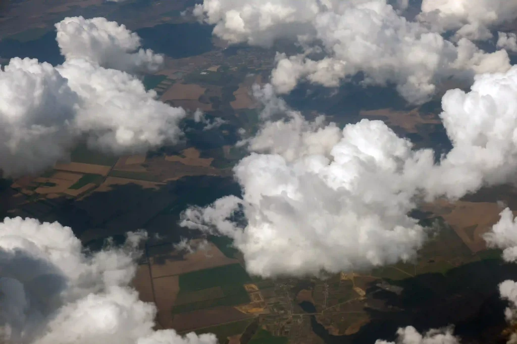 Aerial view from airplane window of white puffy cloud